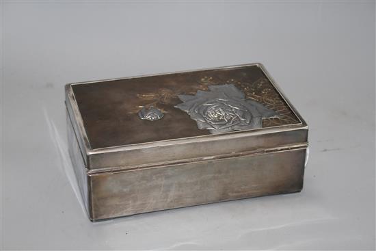 A Japanese silver, copper and gold cigarette box, Meiji period, decorated with a panel of roses, signed, 22 x 14.5cm, height 8cm